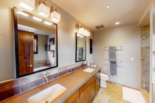 a bathroom with a sink and a mirror and a toilet at Howelsen Panoramic Views in Steamboat Springs
