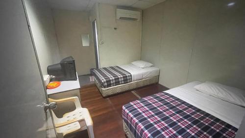 a small room with two beds and a mirror at Hotel 59 in Sibu