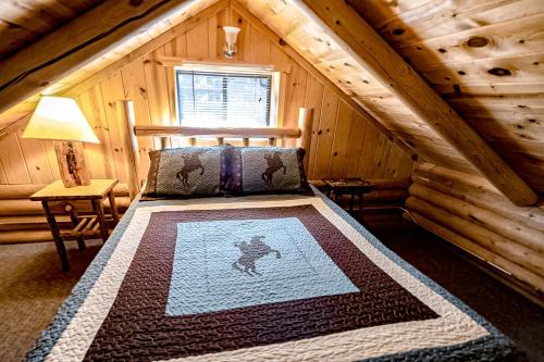 1 dormitorio con 1 cama en una cabaña de madera en Experience Montana Cabins - Cowboy #5, en Bigfork