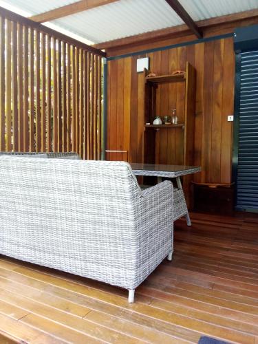 a wicker couch and a table in a room at Bungalow de charme in Montjoly