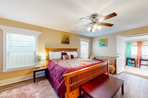 a bedroom with a bed and a ceiling fan at Betty's Beach House in Galveston