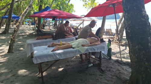un grupo de personas tumbadas en las camas de la playa en Evan Room, en Quepos
