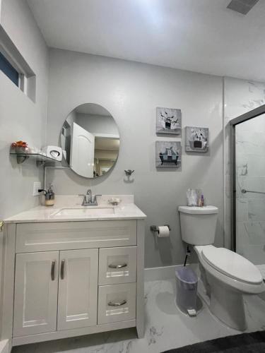 uma casa de banho com um WC, um lavatório e um espelho. em Fantastic Suite em Las Vegas