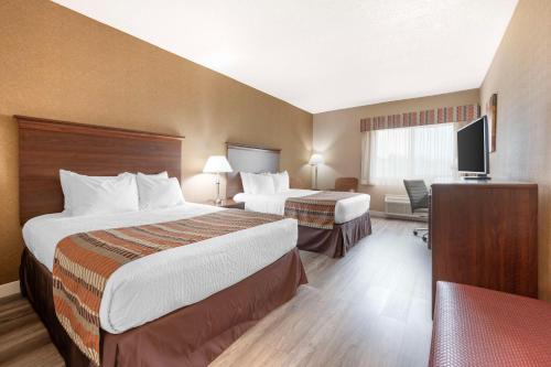 een hotelkamer met 2 bedden en een flatscreen-tv bij Best Western Circus City Inn in Peru