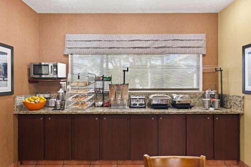 a kitchen with a counter top with a window at Best Western Port St. Lucie in Port Saint Lucie