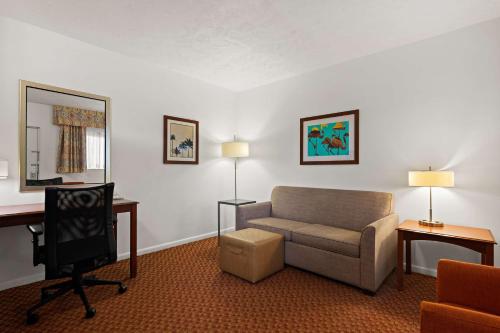 a living room with a couch and a chair and a desk at Best Western Port St. Lucie in Port Saint Lucie