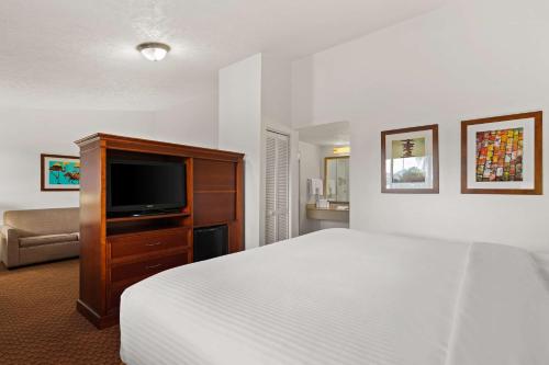 a hotel room with a bed and a flat screen tv at Best Western Port St. Lucie in Port Saint Lucie