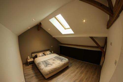 a attic bedroom with a bed and a skylight at L'Atypique Vosgien in Bussang
