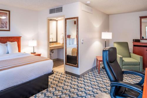 a hotel room with a bed and a chair at Best Western Vista Inn at the Airport in Boise