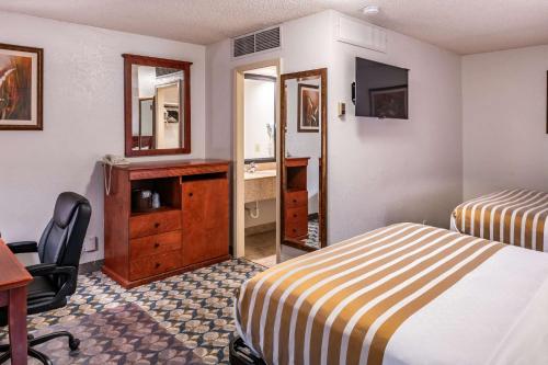a hotel room with two beds and a desk and a mirror at Best Western Vista Inn at the Airport in Boise