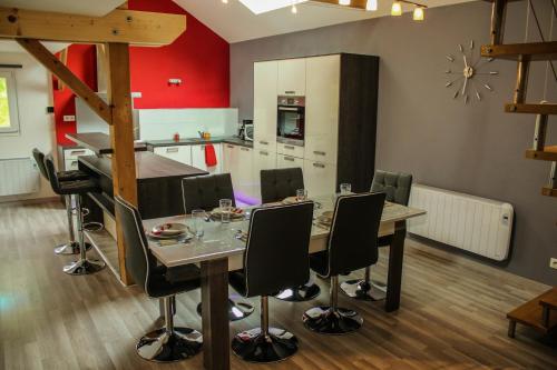 une cuisine et une salle à manger avec une table et des chaises dans l'établissement L'Atypique Vosgien, à Bussang