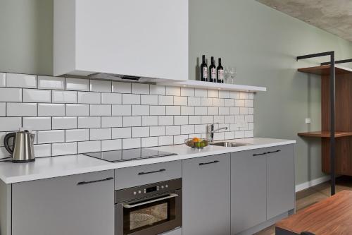 a white kitchen with a sink and a stove at Corendon Apartments Amsterdam Schiphol Airport in Badhoevedorp