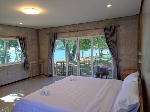 Lomtalay Resort Trat في Ban Bang Pit Lang: غرفة نوم بسرير ابيض مطلة على المحيط