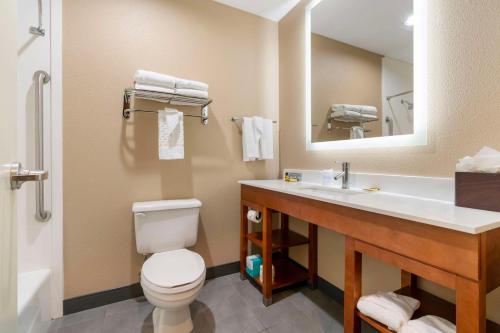 a bathroom with a toilet and a sink and a mirror at Best Western Bend North in Bend