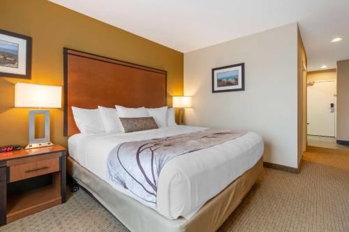 a hotel room with a large bed and a table at Best Western Bend North in Bend