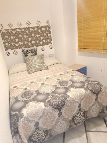 a bedroom with a bed with a black and white comforter at Mccoy avenida 3 in Macael