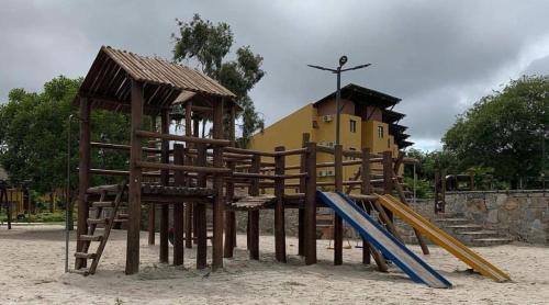 a playground with a wooden play structure and a slide at FLAT GRAVATÁ WINTERVILLE 1214 in Gravatá