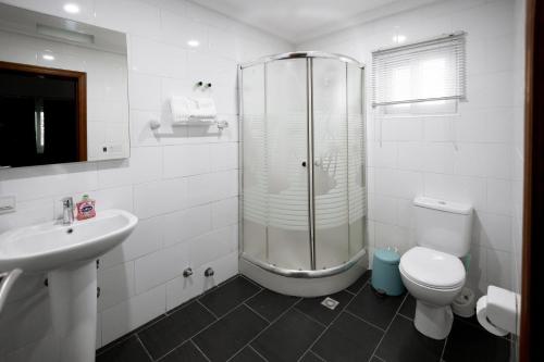 e bagno con doccia, servizi igienici e lavandino. di Luxurious Estate a Sekondi-Takoradi