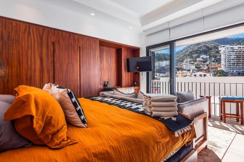 a bedroom with a large orange bed with a large window at Madero 320 - 310 in Puerto Vallarta