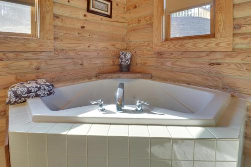 a bath tub in a bathroom with wooden walls at Big Bear Lodge - Cabin in Massanutten Resort! in McGaheysville