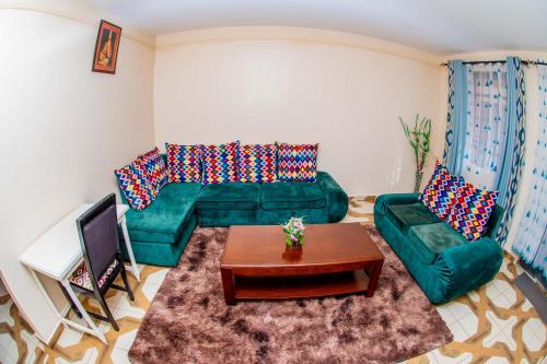 a living room with a green couch and a table at A&B Cozy Retreat Kitale in Kitale
