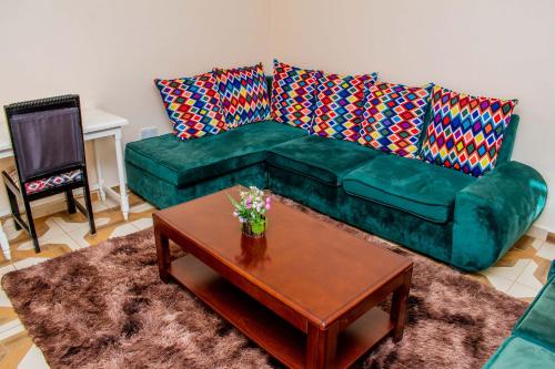 a living room with a green couch and a coffee table at A&B Cozy Retreat Kitale in Kitale