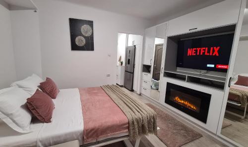 a bedroom with a bed with a tv and a fireplace at Cosy and stylish studio in Bucharest