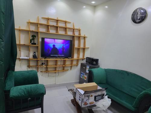 een woonkamer met een groene bank en een tv bij Studio indépendant virage in Dakar