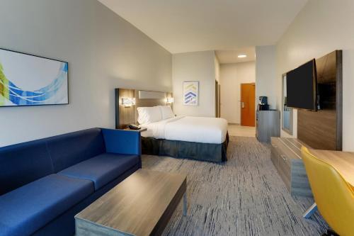 a hotel room with a bed and a couch at Holiday Inn Express Leland - Wilmington Area by IHG in Leland
