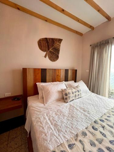 a bedroom with a white bed with a leaf on the wall at Colonial Beach Airport Hotel in Cartagena de Indias