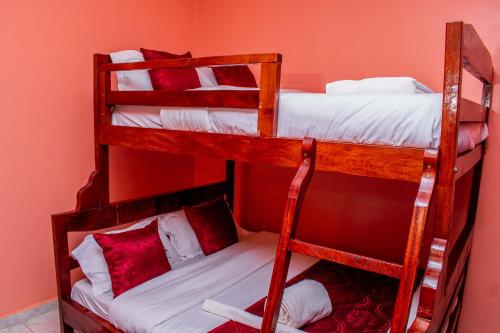 two bunk beds in a room with red walls at A&B Cozy Apartments Kitale in Kitale