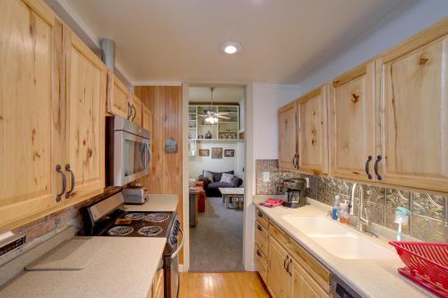 a kitchen with wooden cabinets and a counter top at Walk to Water St and River Quaint Saugatuck Apt in Saugatuck