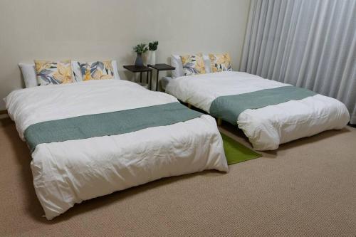 Ένα ή περισσότερα κρεβάτια σε δωμάτιο στο ファミリーに最適！5LDKで16名まで！今里徒歩8分で静か。なんば心斎橋 日本橋10分圏で駐車場無料