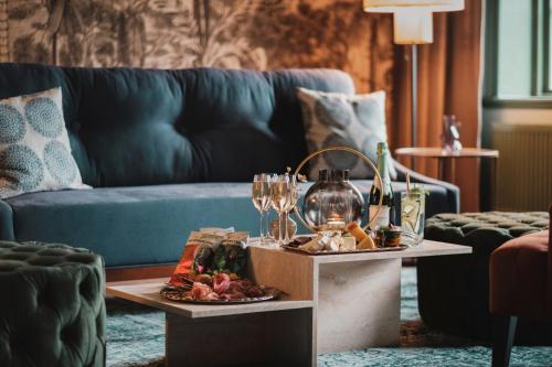 una sala de estar con una mesa con copas de vino y un sofá en Lejondals Slott, en Bro