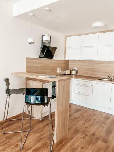 - une cuisine avec un comptoir en bois, une table et des chaises dans l'établissement Cozy apartment next to Presidential palace, à Bratislava