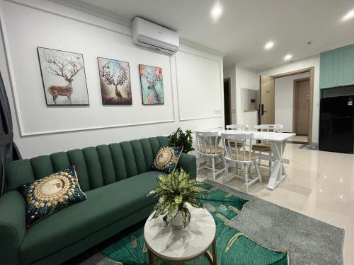 een woonkamer met een groene bank en een tafel bij Moon homestay, apartment Hue in Hue