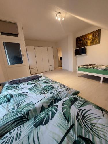 - une chambre dotée d'un lit avec une couverture bleue et verte dans l'établissement Reinfeld Zentral, à Reinfeld