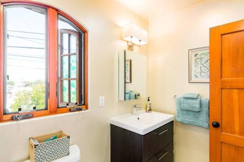 baño con lavabo y ventana en The Little Pumpkin Guest House, en San Diego