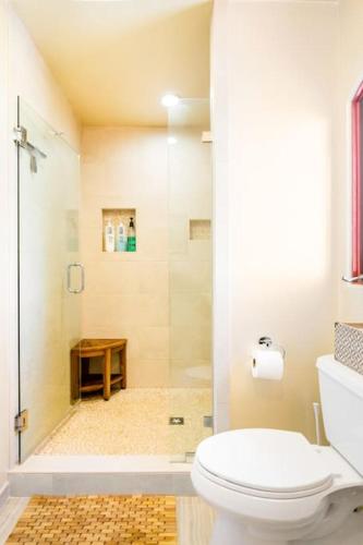 a bathroom with a white toilet and a shower at The Little Pumpkin Guest House in San Diego
