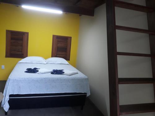 a bedroom with a bed with two towels on it at Chales Da Mata in Fortim