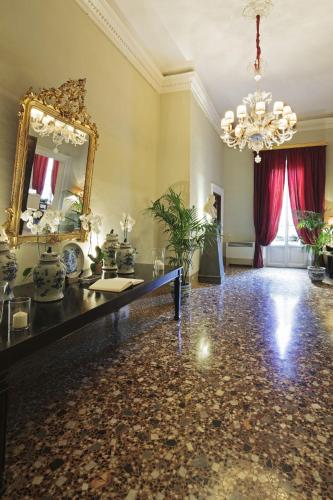 a large room with a mirror and a vanity and a chandelier at Al Palazzo del Marchese di Camugliano Residenza d'Epoca in Florence
