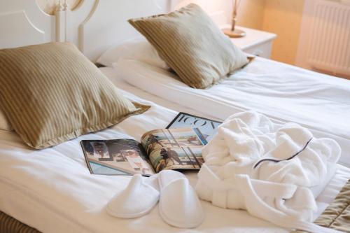 a bed with white shoes and a book on it at Lejondals Slott in Bro