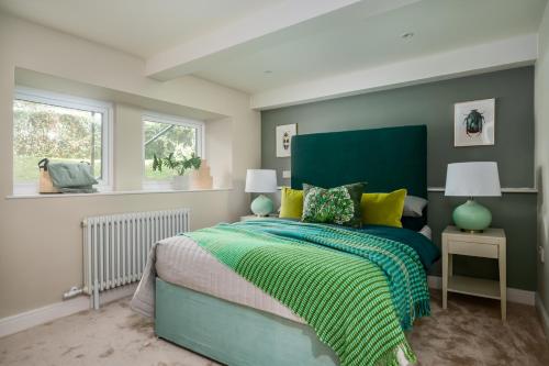 a bedroom with a bed with a green and yellow blanket at Kist Accommodates - Hughenden Haven in Harrogate