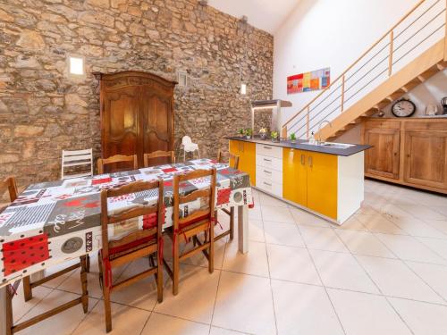 a kitchen with a table with chairs and a stone wall at Charming holiday home in Durbuy with garden in Durbuy