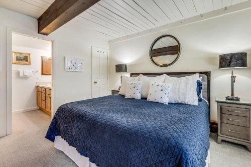 a bedroom with a blue bed and a mirror at Interlude Condominiums 3-Bedroom Unit 301 in Snowmass Village