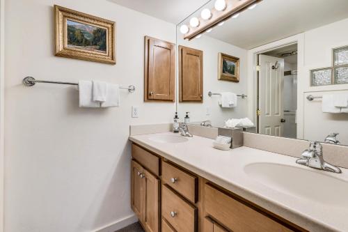 Baño con 2 lavabos y espejo en Interlude Condominiums 3-Bedroom Unit 301 en Snowmass Village