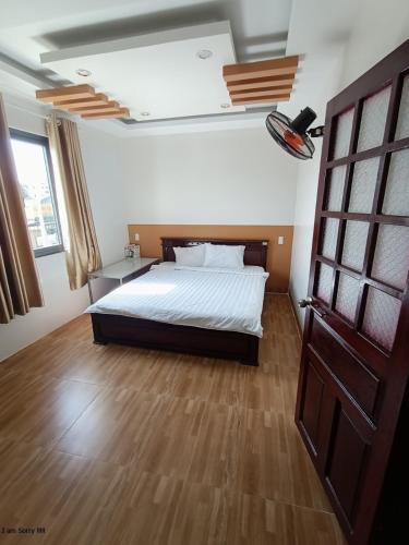 um quarto com uma cama e piso em madeira em Trung Hiếu em áº¤p VÄ©nh ÃÃ´ng