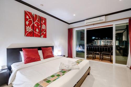 a bedroom with a bed with red pillows and a window at Napalai Resort & Spa in Hua Hin