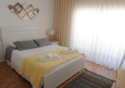 a bedroom with a bed with two towels on it at APARTAMENTO CENTRAL in Mondim de Basto