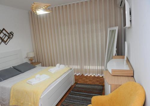 een kleine slaapkamer met een bed en een stoel bij APARTAMENTO CENTRAL in Mondim de Basto